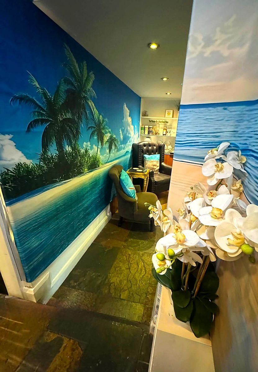 White orchids on a stand at the turn from the lounge into the treatment corridor